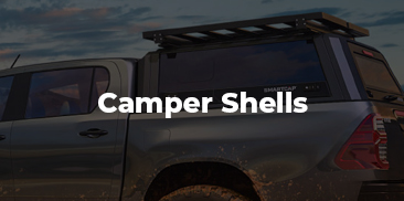 A truck camper shell installed on a gray truck.