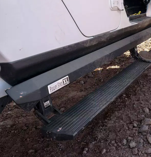 An Amp Power Step XL, installed on a white truck.