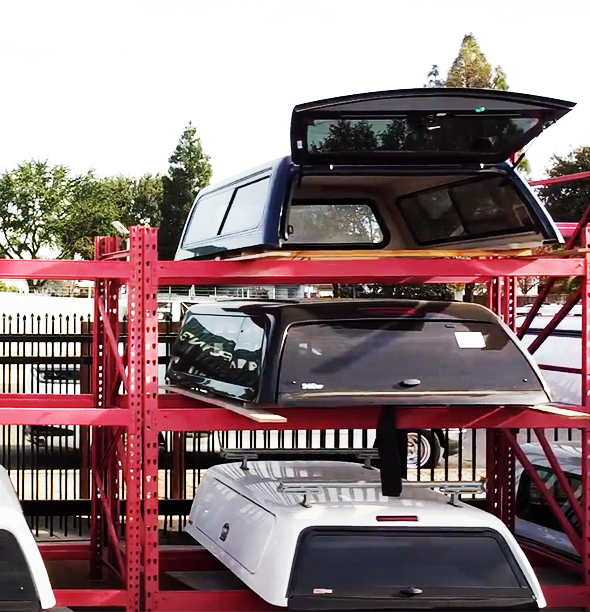 An outdoor rack with a few truck camper shells.