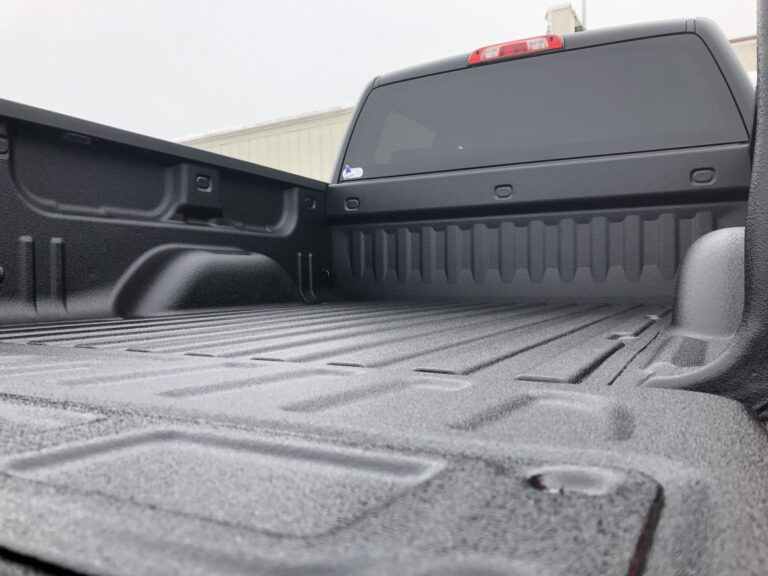 Pickup truck with an open tailgate showing off a liner